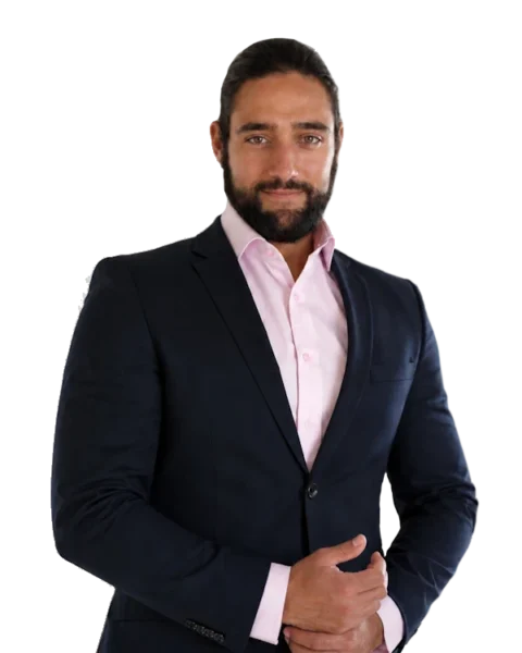 Mann in Anzug mit rosa Hemd, freundlich lächelnd, vor transparentem Hintergrund. Professionelles Porträt für Business und Corporate-Profile.