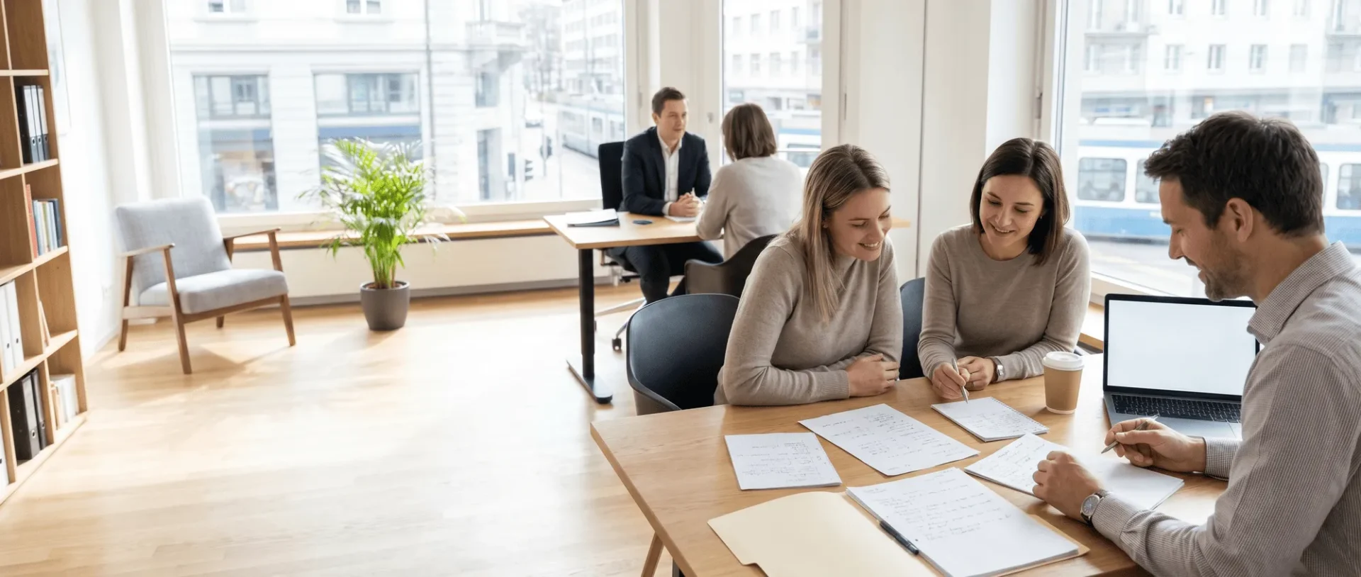 Büroarbeitsteam bei einer Besprechung, konzentriert auf Dokumente und Notizen, mit Fensterblick in einem modernen, hellen Arbeitsbereich.